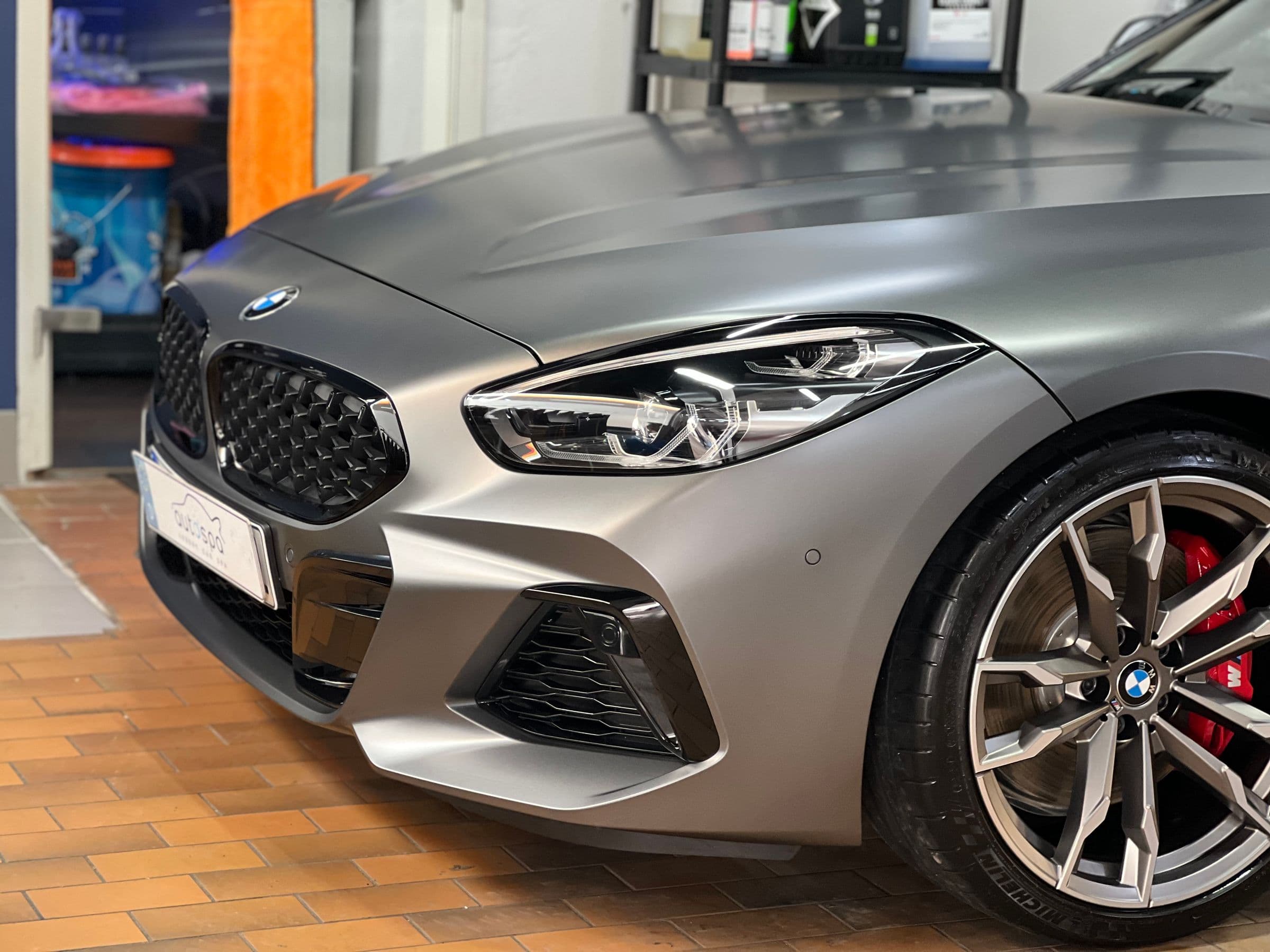 Nahaufnahme der Front eines mattgrauen BMW Z4 mit Doppelniere und Scheinwerfer