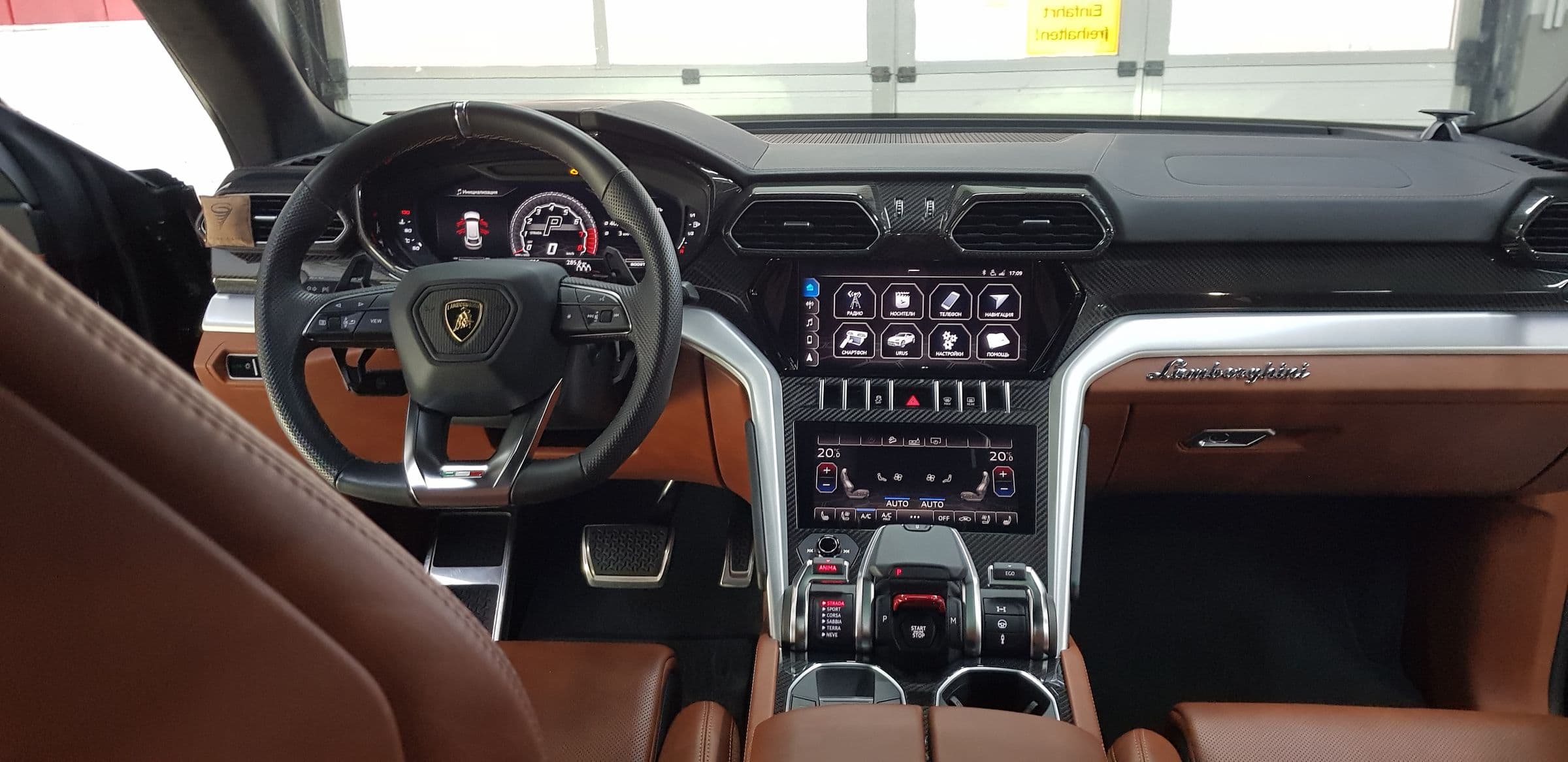 Innenraum eines Lamborghini Urus mit cognacfarbenem Leder und Mitteldisplay
